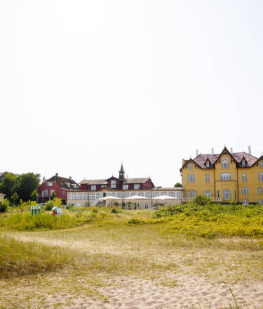 Ta en pause på Aarøsund Badehotel, hvor det gule huset har ønsket gjester ved sjøen velkommen siden 1903.
