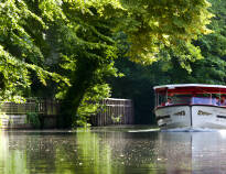 Reis på en fantastisk tur med Odense Å-båt, som seiler forbi byens prisbelønte Zoo.