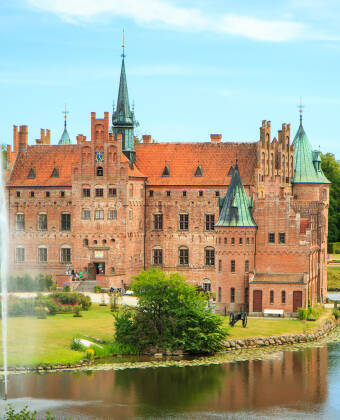 Oplev Egeskov Slot som byder på veteranbiler, labyrinter og meget andet i en fortryllende setting.