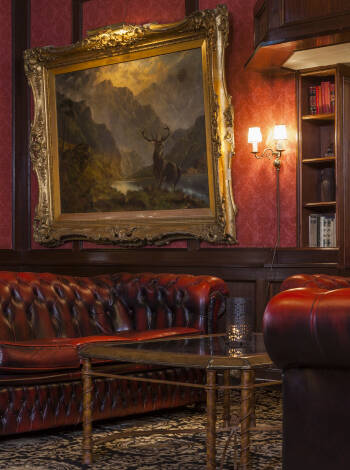 The reception area is hung with chandeliers and stylishly furnished with burgundy Chesterfield chairs.