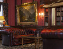 I receptionsområdet hænger der lysekroner og en lækker indretning med Chesterfield-stole i vinrød.