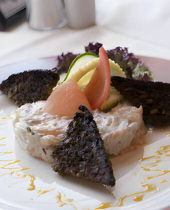 Bei schönem Wetter können Sie auch auf der gemütlichen überdachten Terrasse des Hotels essen.