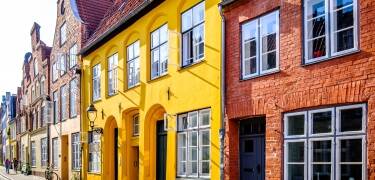 Spadser forbi historiske gavlhuse, små butikker og Lübecks berømte kirketårne.