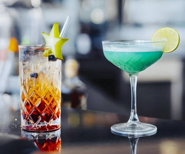 Genießen Sie Drinks an der stilvollen Hotelbar hoch über den Dächern der Stadt.