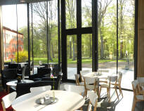 Frukosten serveras i en stor ljus matsal med utsikt över den vackra parken som ligger utanför fönstret.