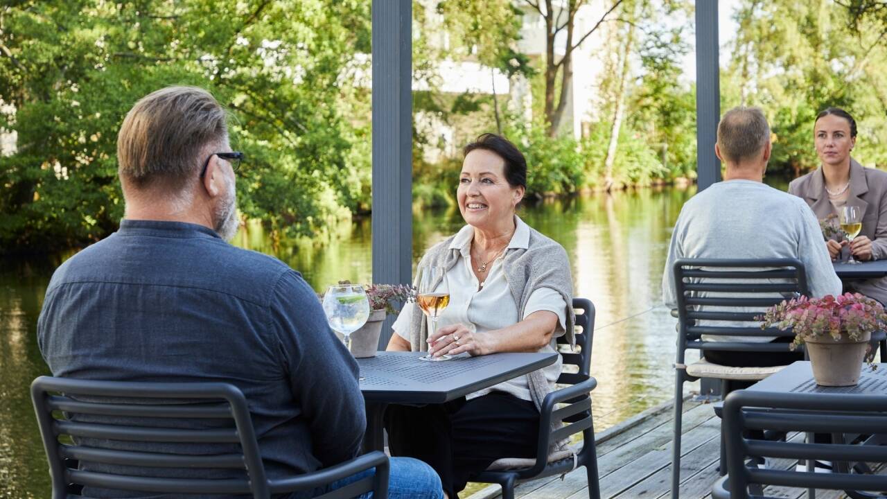 Njut av ett gott vin och välkomnande atmosfär på hotellets idylliska terrass vid floden.