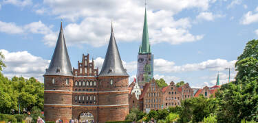 Erleben Sie spannende Sehenswürdigkeiten wie das Holstentor, machen Sie einen Einkaufsbummel und probieren Sie das berühmte Lübecker Marzipan.