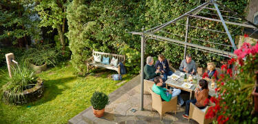 Nyd et koldt glas hvidvin i godt selskab i hotellets hyggelige have