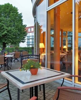 Slapp av på hotellets terrasse med en kaffe eller noe godt fra kafeen, omgitt av grønne omgivelser og frisk sjøluft.