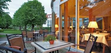 Entspannen Sie sich auf der Hotelterrasse bei einem Kaffee oder einer Leckerei aus dem Café, umgeben von viel Grün und frischer Meeresluft.