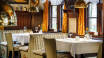 Hotellets velrenomerede restaurant, byder på udsøgt mad i en historisk atmosfære.