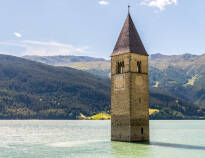Kyrktornet som står mitt i vattnet i Reschensee är ett av områdets mest kända landmärken