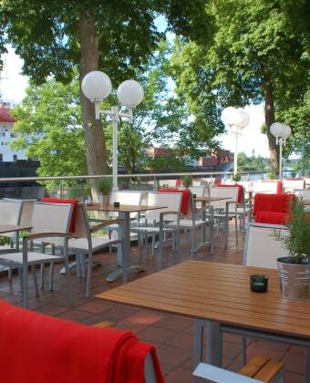 Slå dere ned på hotellets terrasse og følg med på den seilende trafikken som går nedover elva.