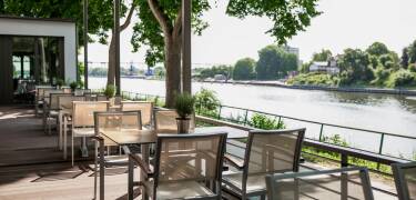 Slå dere ned på hotellets terrasse og følg med på den seilende trafikken som går nedover elva.