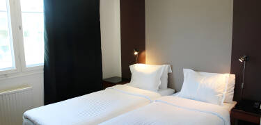 Hotellets værelser er lyse med parketgulve og senge fra Hilding Anders.