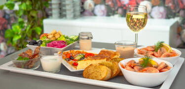 Stehen Sie für ein köstliches Frühstück mit warmen und kalten Gerichten auf und genießen Sie es in den Außenpavillons des Hotels oder in der Frühstückslobby.