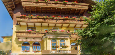 Hotellet är byggt i traditionell alpin stil och har balkonger med vacker utsikt.