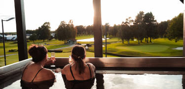 Die Gäste können sich im Außen-Whirlpool mit Blick auf den Golfplatz entspannen.