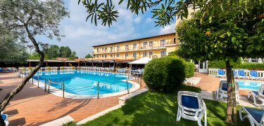 Slapp av ved bassenget og nyt livet under en av parasollene på hotellets vakre solterrasse