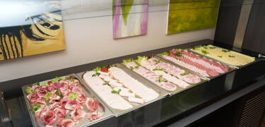 Each morning begins with a generous breakfast buffet offering a varied selection of fresh bread, cold cuts, fruit, and hot drinks.