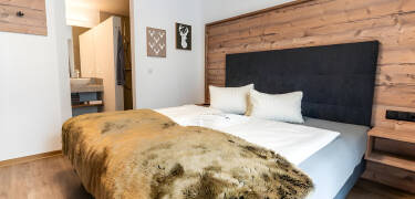 Übernachten Sie in gemütlichen Zimmern mit viel Holz und modernem Design.