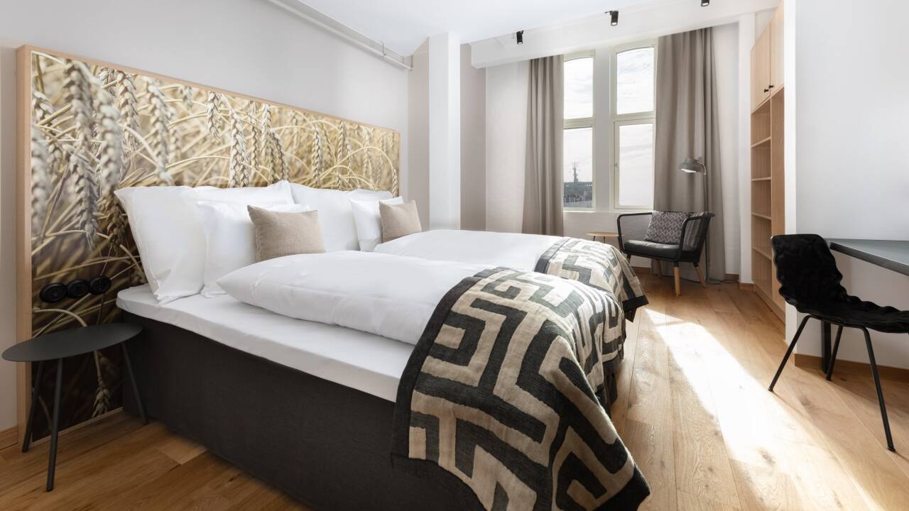 The hotel's beautiful Deluxe rooms are located on the 6th floor and have high ceilings and views of either the sea or the city rooftops.