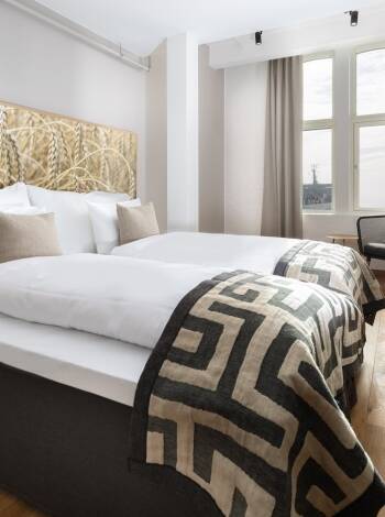 Hotellets fina deluxe-rum ligger på våning 6, har högt i tak och utsikt antingen mot havet eller stadens takåsar