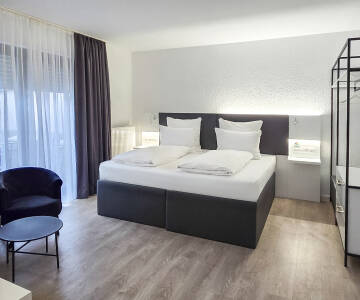 Entspannen Sie in modernen Designerzimmern mit kostenfreier Minibar bei Anreise.