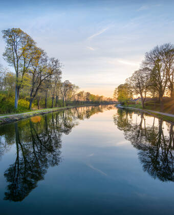Se kanalbåtarna glida förbi på Göta kanal, med ett fantastiskt läge direkt på hamnpiren.