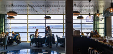 Genießen Sie eine Mahlzeit und bewundern Sie das Panorama im schönen Restaurant.