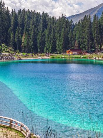Besök Montagnoli-sjön, känd för sitt turkosblå vatten och en perfekt plats för en avkopplande picknick i ett fantastiskt naturligt solarium i Dolomiterna.