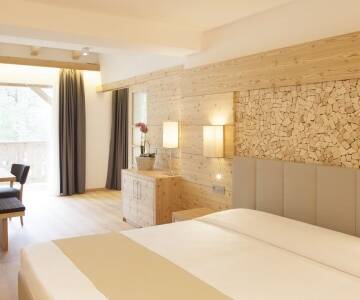 Die Einrichtung der modernen Zimmer stellt immer eine Verbindung zur Natur der Dolomiten her.