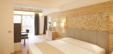 Die Einrichtung der modernen Zimmer stellt immer eine Verbindung zur Natur der Dolomiten her.