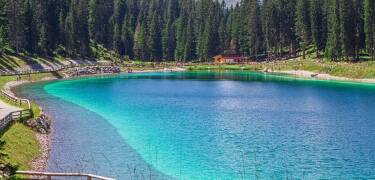 Besøk Montagnoli-sjøen, kjent for sitt turkisblå vann og perfekte sted for en avslappende piknik i et fantastisk naturlig solarium i Dolomittene.
