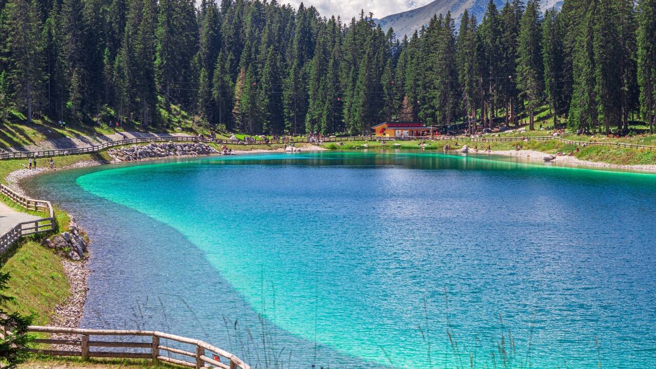Besøk Montagnoli-sjøen, kjent for sitt turkisblå vann og perfekte sted for en avslappende piknik i et fantastisk naturlig solarium i Dolomittene.