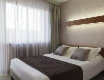 Hotellets flotte og komfortable rom er innredet i myke farger med trepanel og stilfulle møbler.