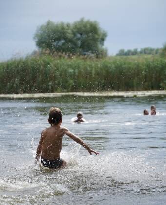 Das klare Wasser und die reizvolle Umgebung des Hugnsees laden zu einer erfrischenden Abkühlung ein.