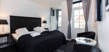 Alle Zimmer verfügen über ein eigenes Bad, einen gemütlichen Sitzbereich, Kaffee- und Teezubehör, bequeme Betten und einen TV.