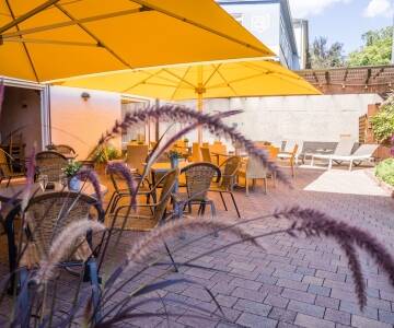 Planera dina utflykter under en solig dag med en drink på hotellets innergård.