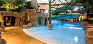 Tauchen Sie ein in den tropisch gestalteten Wasserpark des Hotels mit Rutschen, Whirlpools und ganzjährigem Spaß für alle Altersgruppen.