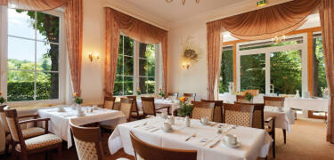 Das Hotelrestaurant mit seinem gemütlichen Kamin bietet ein warmes und einladendes Speiseerlebnis.