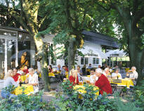 Njut av en uppfriskande drink i den charmiga ölträdgården eller på terrassen, omgiven av frodig grönska och fridfull atmosfär.