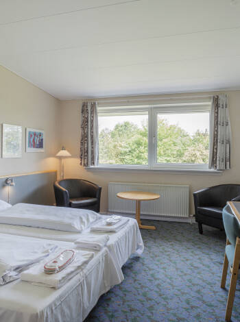 Slappna av på hotellets bekväma och rymliga rum efter en upplevelserik dag på Fyn.