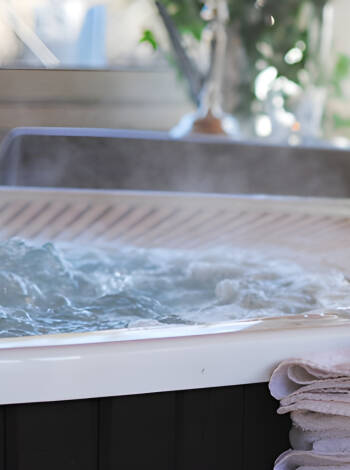 Lehnen Sie sich im Whirlpool des Hotels draußen im verglasten Pavillon im Garten zurück.