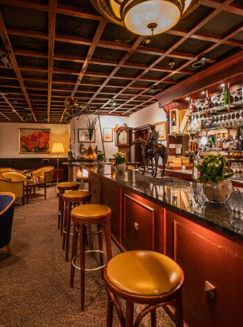 Die charmante Bar mit Kamin bietet eine entspannte Atmosphäre für einen Kaffee, ein Getränk oder eine leichte Mahlzeit.