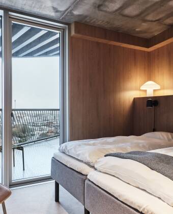 Genießen Sie die schlichte, raue Inneneinrichtung und den privaten Balkon in jedem Zimmer, der einen herrlichen Blick auf das Meer oder die Stadt bietet.