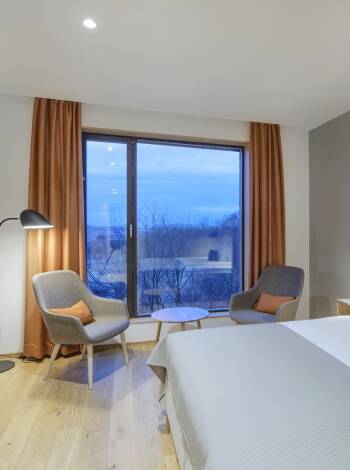Hotellets lyxiga rum är inredda med parkettgolv och stora fönster från tak till golv.