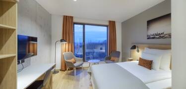 The hotel's luxurious rooms are decorated with parquet floors and large ceiling-to-floor windows.