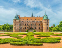 Erleben Sie Schloss Egeskov, die größte Touristenattraktion Fünens, in dem es spannende Ausstellungen, ein großes Naturlabyrinth und barocke Gärten gibt..