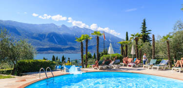 There is an outdoor swimming pool with sun loungers, parasols, a children's pool, and a pool with waterslide.